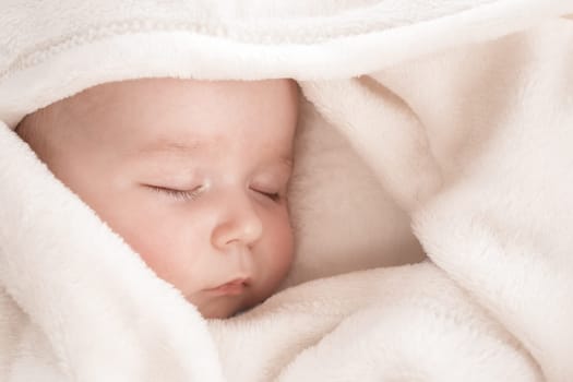 little boy sleeping on soft white blanket