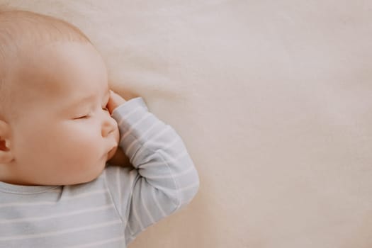 little boy sleeping on soft white blanket