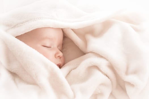 little boy sleeping on soft white blanket