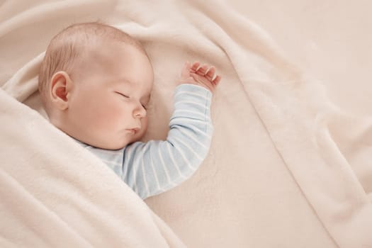 little boy sleeping on soft white blanket