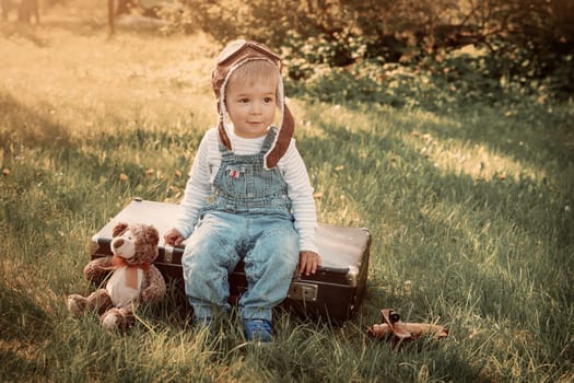 Boy playing in aviator hat in the garden in summer