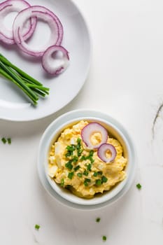 Egg spread with onion and chives on marble background