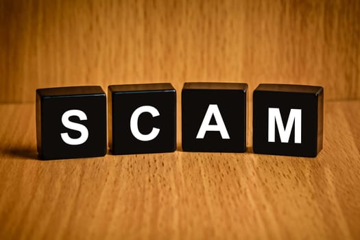 Scam, fraud text on black block, technology security concept