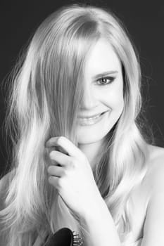 Woman has fun smiling laughing while brushing out her hair