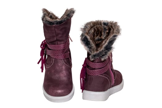 Kids boots isolated. Close-up of a pair elegant violet suede leather winter boots and lined with brown fur. Girls winter shoe fashion new trends isolated on a white background. Macro photograph.
