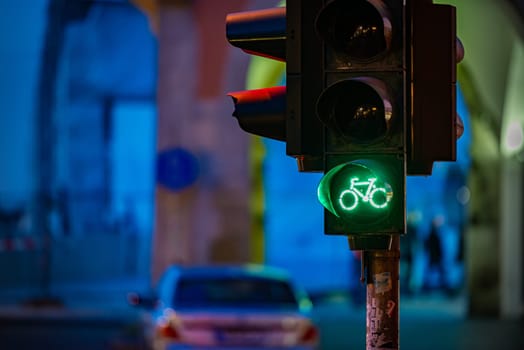 Traffic light in Munich, Bavaria, Germany. Green bicycle icon with night street in background. Travel and transportation in Europe.