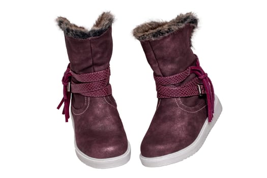 Winter shoes isolated. Close-up of a pair elegant violet suede leather winter boots and lined with brown fur. Girls winter shoe fashion new trends isolated on a white background. Macro photograph.