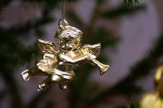 Christmas card with golden angel playing on a mandolin on a Christmas tree. Christmas card with blured background