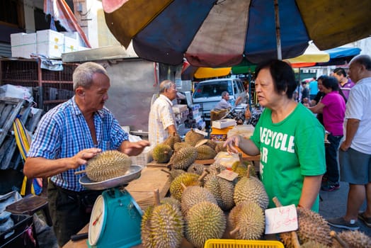 Georgetown, Penang/Malaysia - Jul 30 2016: Durian hawker weight the durian with scale at the wet market.