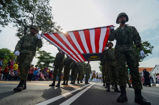 Georgetown, Penang/Malaysia - Aug 31 2016: Low angle soldiers carry large Malaysia flag together.