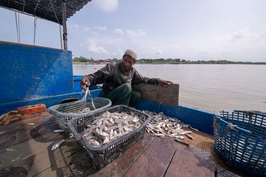 Kuala Muda, Penang/Malaysia - Mar 19 2017: Fisherman put the fish into larger basket and prepare sell in market.