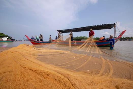Kuala Muda, Penang/Malaysia - Mar 19 2017: Fishermen repair fishing net.