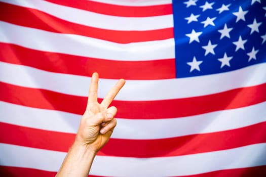 Man's hand showing victory over USA flag.United States elections 2020 concept.