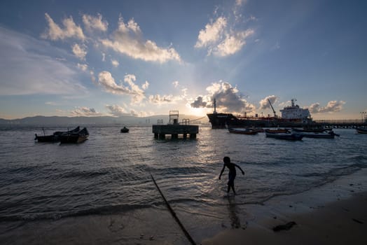 George Town, Penang/Malaysia - Jun 27 2017: A kid run at the beach during amazing sky in evening.