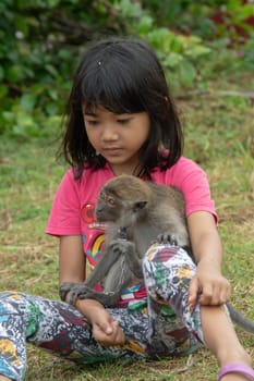 Kota Bahru, Kelantan/Malaysia - Jul 15 2017: A girl hug the monkey pet at field.