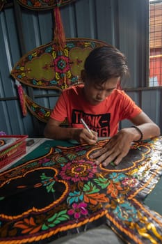 Kota Bahru, Kelantan/Malaysia - Jul 15 2017: An unidentified man cut the shape of traditional Malays moon kite.