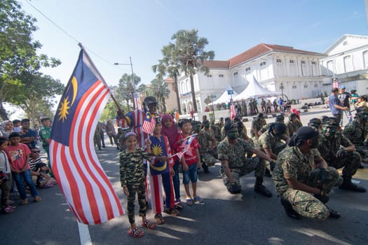 George Town, Penang/Malaysia - Aug 31 2017: Patriotic Malaysia wave Malaysia flag beside soldier.