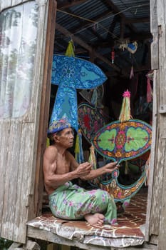 Kota Bahru, Kelantan/Malaysia - Jul 15 2017: A man sit and hold wau.