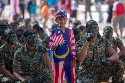George Town, Penang/Malaysia - Aug 31 2017: A kid wear Malaysia costume take photo with soldier.
