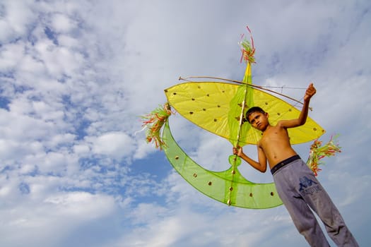 Kota Bahru, Kelantan/Malaysia - Jul 15 2017: A local Malays child carry moon kite under blue sky.