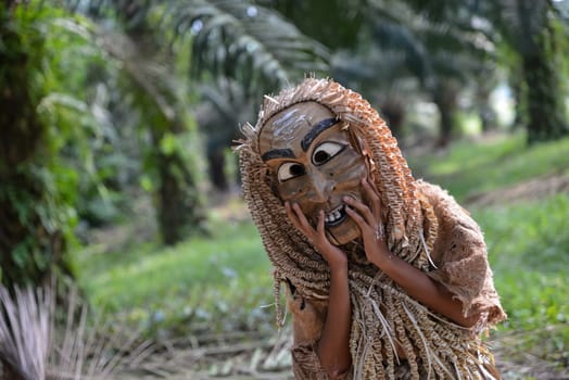 Carey Island, Selangor/Malaysia - Mar 17 2018: Malaysia aborigine Mah Meri with mask at oil palm estate