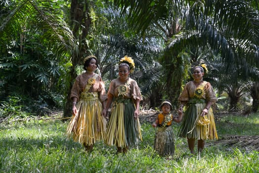 Carey Island, Selangor/Malaysia - Mar 17 2018: Malaysia's indigenous Mah Meri walk in oil palm plantation.