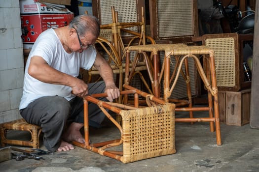 George Town, Penang/Malaysia - Jul 19 2018: A man repair rattan chair.