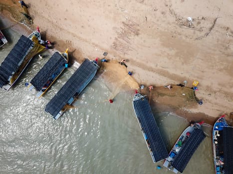 Kuala Muda, Penang/Malaysia - May 24 2019: Aerial view fisherman clear the small fish trap at the net.