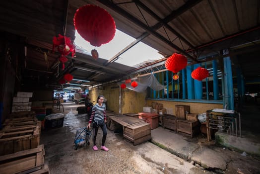 Bukit Mertajam, Penang/Malaysia - Jun 14 2019: A woman pass over the path at morning market