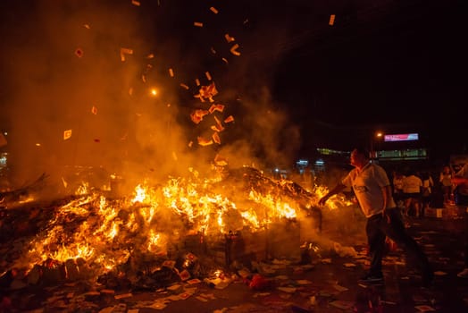 Bukit Mertajam, Penang/Malaysia - Aug 17 2019: People throw offering into the flames during hungry ghost festival.