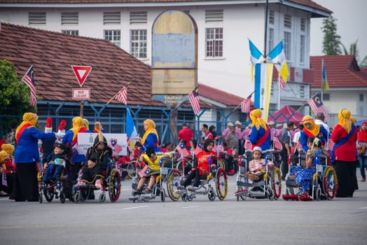 Butterworth, Penang/Malaysia - Aug 31 2019: Kids in wheel chair join Merdeka parade at street.
