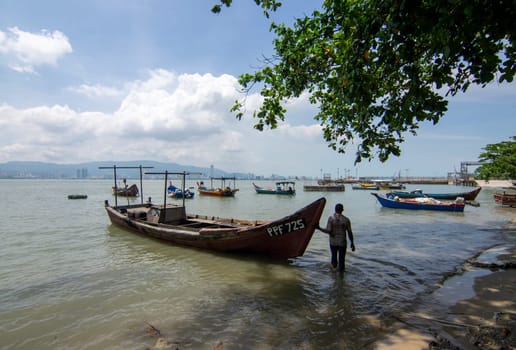 Butterworth, Penang/Malaysia - Oct 12 2019: Fisherman beside boat.