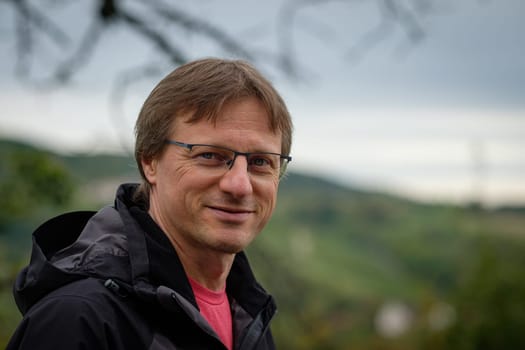 Smiling caucasian man with glasses and blurred landscape shot