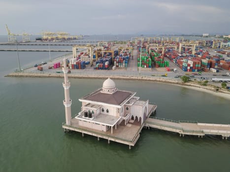 Butterworth, Penang/Malaysia - Nov 06 2019: Butterworth Floating Mosque (Masjid Terapung) with background container terminal.