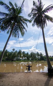 Penaga, Penang/Malaysia - Oct 27 2019: A girl play swing in coconut farm.