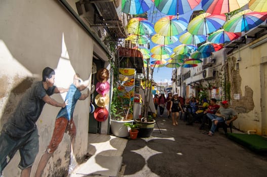 George Town, Penang/Malaysia - Nov 11 2019: Mural art at street near Armenian Street with colorful umbrella hang at sky.