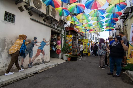 George Town, Penang/Malaysia - Nov 11 2019: Tourist posing in front of Mural at street.