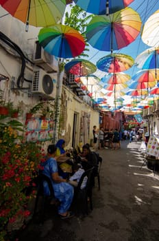 George Town, Penang/Malaysia - Nov 11 2019: A family have rest at the street with colorful umbrella.