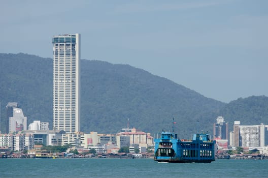 Butterworth, Penang/Malaysia - Jan 01 2020: Blue ferry with KOMTAR building background.