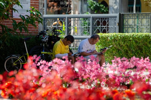 Georgetown, Penang/Malaysia - Jan 03 2020: Two artist drawing at park with red flower decoration during chinese new year.