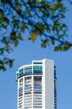 Georgetown, Penang/Malaysia - Jan 03 2020: Penang highest building KOMTAR. Foreground is green leaves.