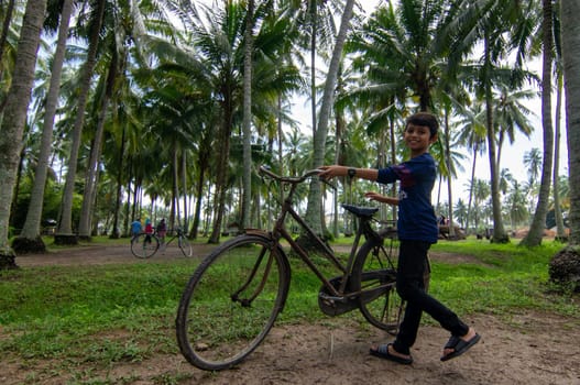 Penaga, Penang/Malaysia - Oct 27 2019: Kids walk with antic bicycle at coconut farm.