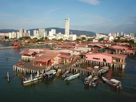 Georgetown, Penang/Malaysia - Feb 28 2020: Aerial view boats anchor near the wooden bridge of traditional chinese clan settlements.