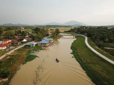 Bukit Mertajam, Penang/Malaysia - Mar 11 2020: Aerial view fishing boat back to jetty near Malays village at Sungai Kulim.