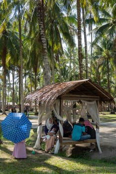 Penaga, Penang/Malaysia - Mar 15 2020: A Malays family rest at wooden hut coconut farm.