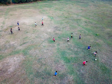 Malays kids have fun cycle, play football in green field.