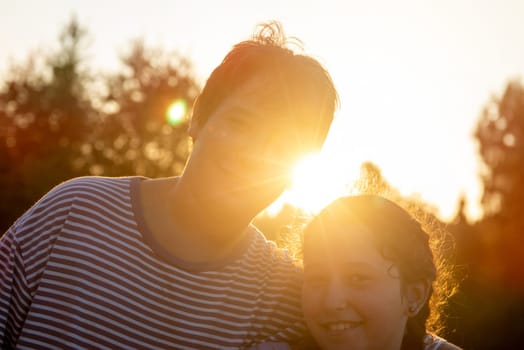 Kid’s couple posing outdoors at sunset