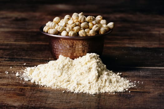 Heap of chickpea flour and bowl with roasted and salted chickpeas