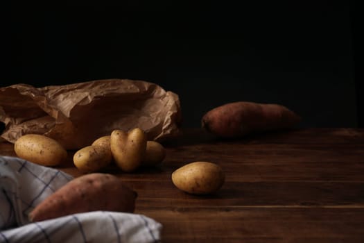 Seasonal food: Potatoes and Yam on wooden table (heart-shaped potato)