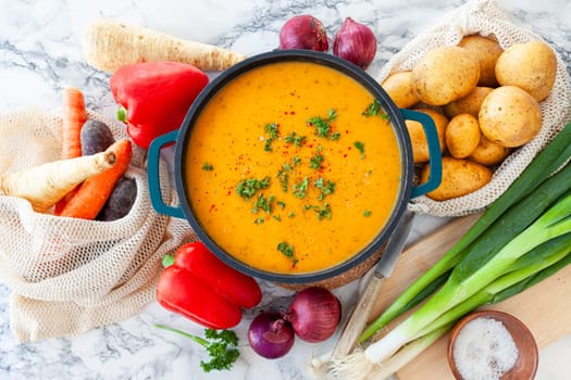 Pot of hearty potato soup with fresh vegetables